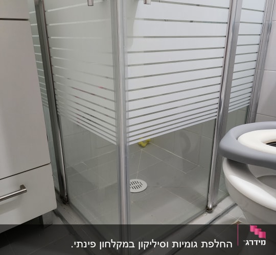 מקלחון זכוכית עם דלתות מתכת וידיות כסופות